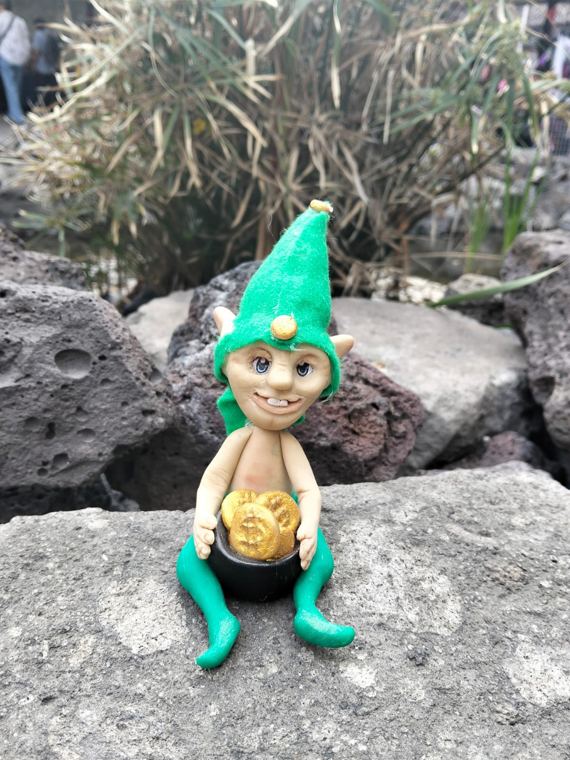 Duende de gorro verde con caldero de monedas