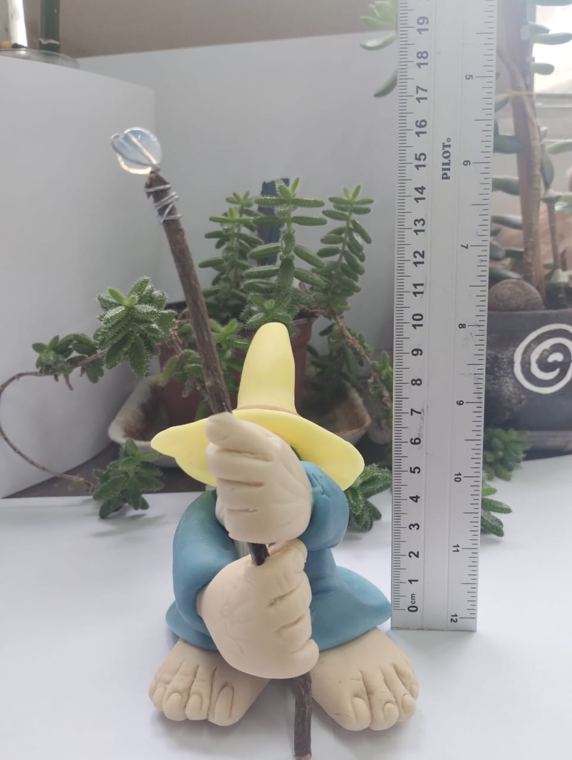 Mago de sombrero amarillo junto a una regla, mide cerca de 18 cm